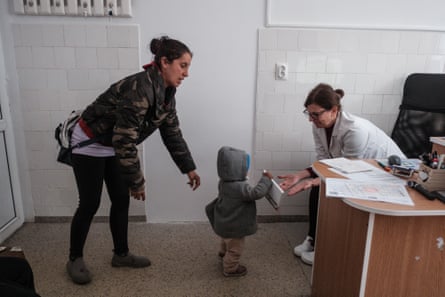 Casandra Stoica with her children during a consultation with Dr Mirela Csabai at the Săcele municipal clinic.
