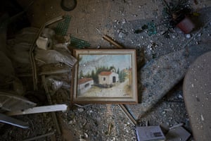 A painting and personal belongings covered with dust and shards of broken glass