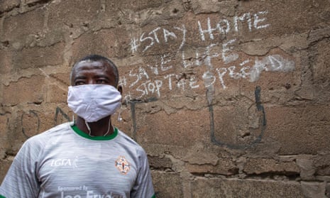 Man poses for a photograph by a wall after the partial lockdown in parts of Ghana to halt the spread of the Covid-19