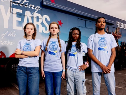 Four teenagers wearing matching FFA shirts pose outside of a truck
