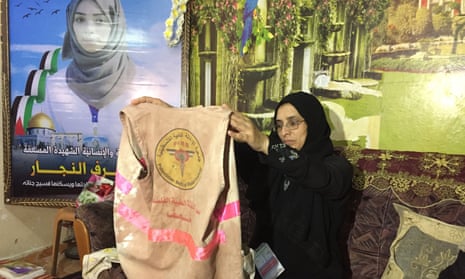 Sabrine al-Najjar holds up the bloodied jacket her daughter, Razan al-Najjar, wore when she was shot by Israeli forces