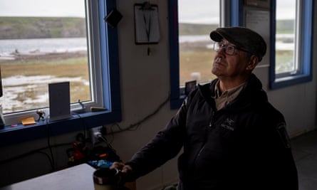 A man in a cap standing by a window