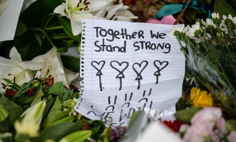 A handwritten note  among flowers during a vigil in Christchurch.