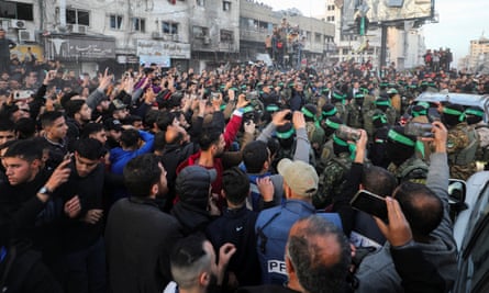 Palestinians gather as Hamas militants prepare to hand over hostages to the Red Cross in Gaza City, 19 January.
