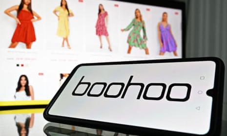 A mobile phone and laptop showing the logo and website of online fashion group Boohoo 