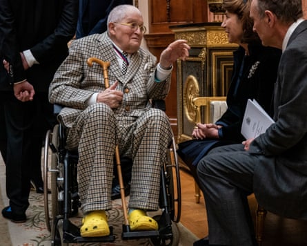 David Hockney in a suit and yellow crocs