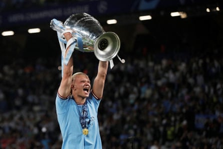 Erling Haaland holds the Champions League trophy aloft in 2023.