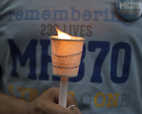 Visitor holds a lit candle to pay tribute to missing passengers during a commemoration event to mark the anniversary of the missing Malaysia Airlines MH370 flight