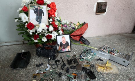 Portraits of journalist Alexander Lashkarava are placed next to a broken camera during his funeral in Tbilisi, Georgia.