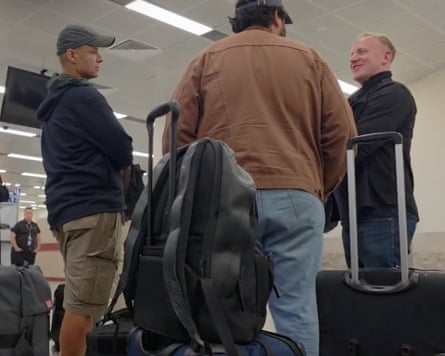 Lewis and Tarry stand with luggage in the checkpoint
