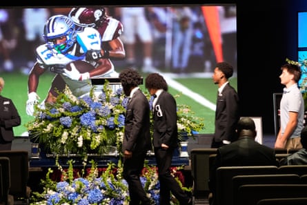 people lining up in front of a casket