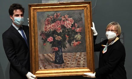 Museum workers hold the painting Flowers