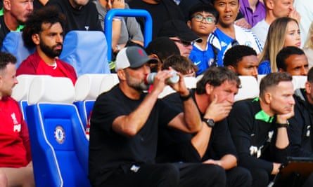 An unhappy-looking Mohamed Salah sits behind Jürgen Klopp after being substituted