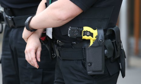 Police officers with Taser electrical weapons.