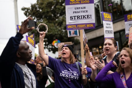 people hold signs during a strike