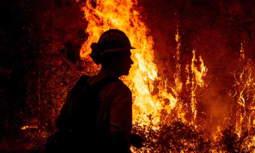 Massive wildfires have gripped the US. Silhouette of firefighter against blaze