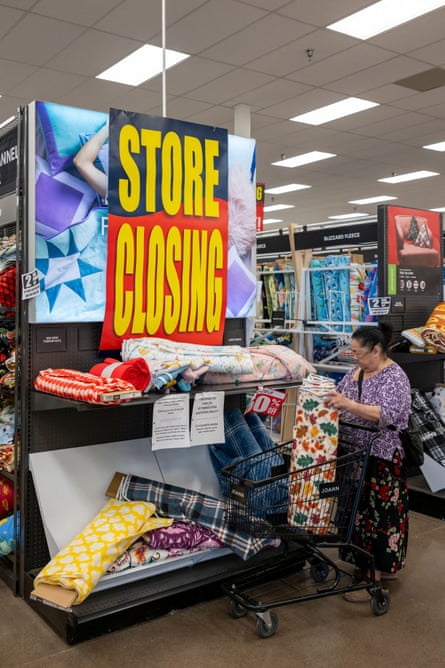 a woman looking at fabric in front of a ‘STORE CLOSING’ sign