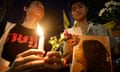 Two people hold candles and one holds a picture of a woman at a vigil for Netiporn Sanae-sangkhom