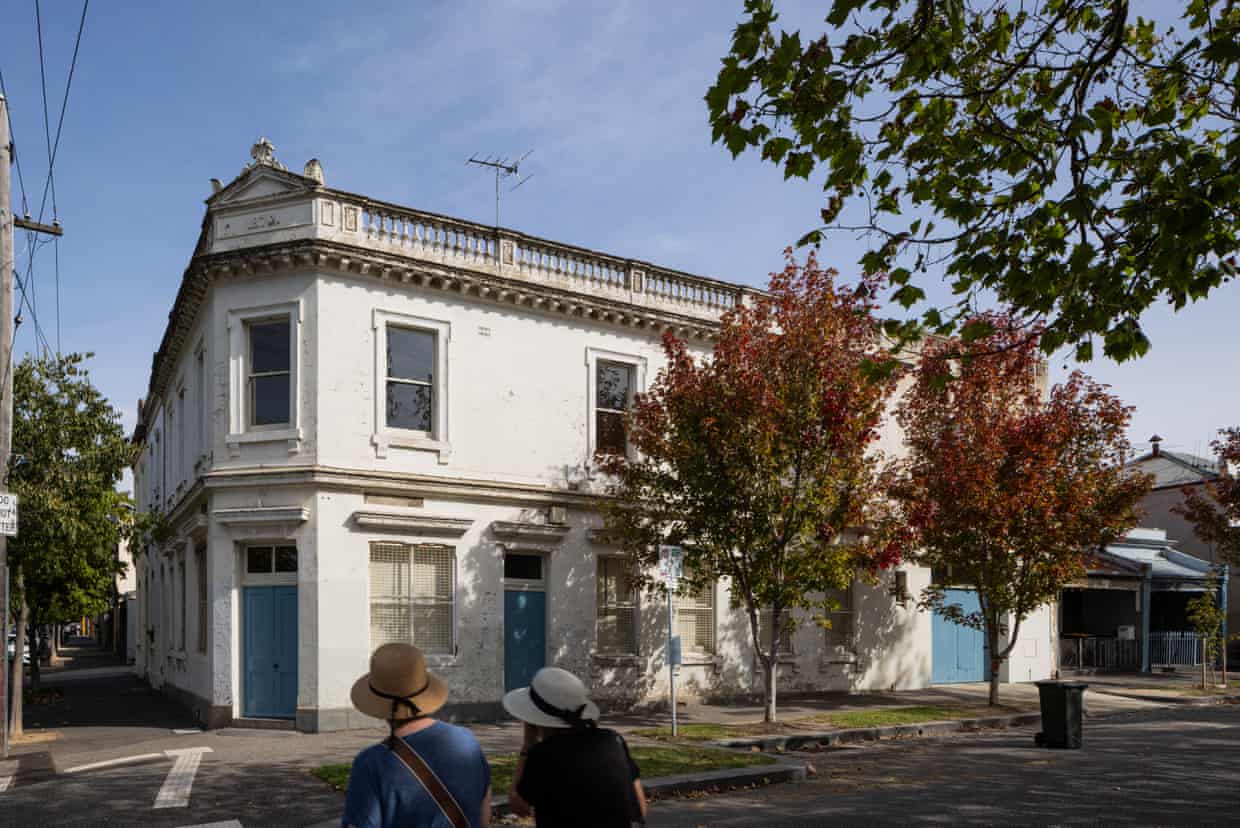 A white two-storey Victorian-era corner terrace