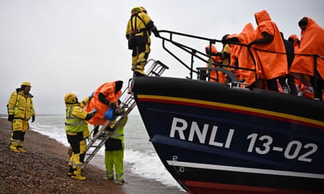 People picked up at sea attempting to cross the  Channel are helped ashore from a lifeboat at Dungeness on the south-east coast of England. 
