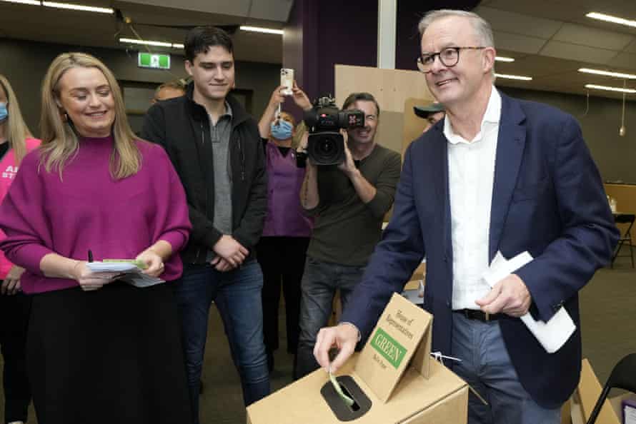 Anthony Albanese casts his ballot, watched by watched by his son Nathan and partner Jodie Haydon