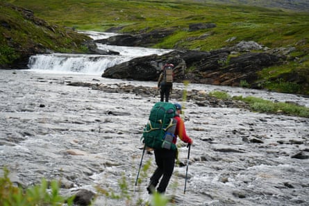 A hiker crossing a river A hiker crossing a river