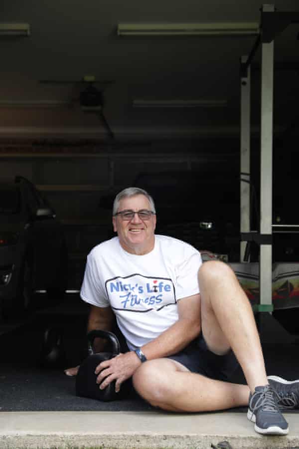 Nick Fowler sits beside some weights in his garage.