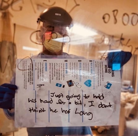 Colby Hutson, a nurse at Ascension Seton Hays in Texas, holds a sign that reads: ‘Just going to hold his hand for a while, I don’t think he has long.’