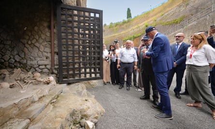 A group of people look at the opening to a boat shed