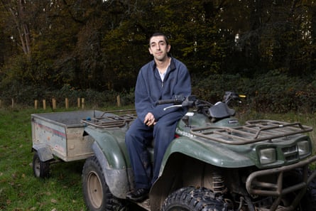 Noah Bennett, in overalls, sits on a farm vehicle