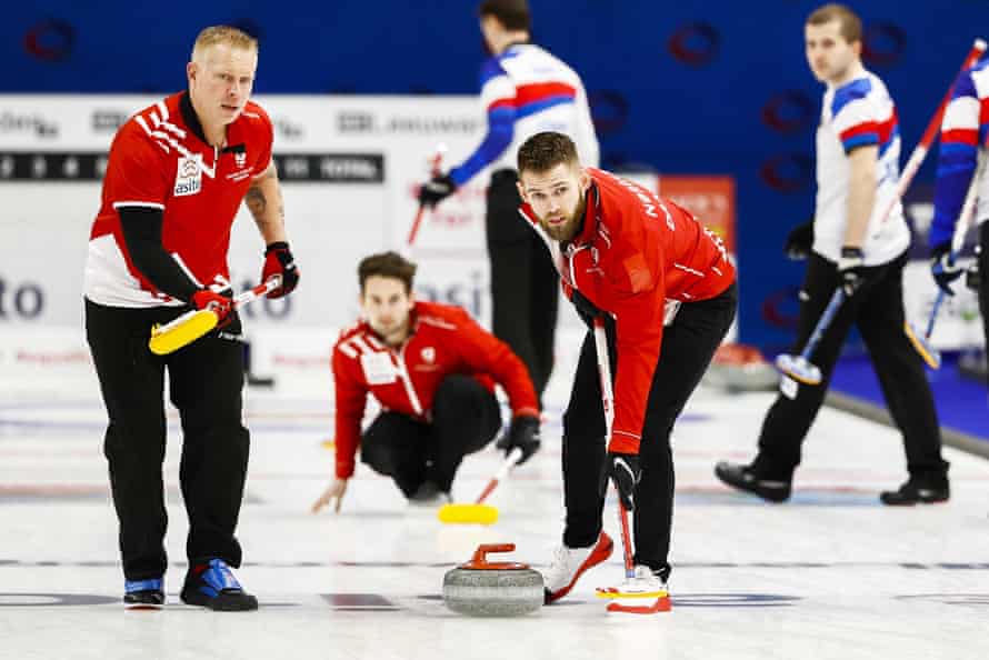 Denmark’s (from left) Kasper Wiksten, Mikkel Krause and Henrik Holtermann compete during the qualification curling tournament.