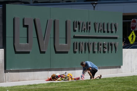 A man kneels by a Utah Valley University sign in Orem, Utah, after the shooting of Charlie Kirk.