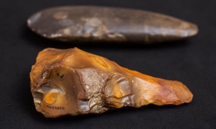 A Neolithic polished flint axe (4000 BCE) and a A Palaeolithic flint hand-axe (250-400,000 BCE) (foreground).