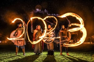 Viking re-enactors use flaming torches to write 2023 during the Flamborough fire festival, a Viking themed parade in aid of charities and local community groups, held on New Year’s Eve near Bridlington