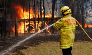Firefighters work to contain a bushfire along Old Bar Road in Old Bar, NSW