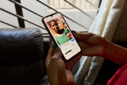 Someone holds a phone with a picture of a young African woman holding a young child