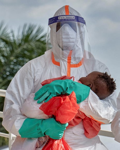 Congolese medical workers in PPE cradle sleeping children cleared of Ebola