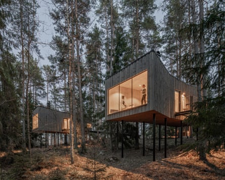 Exterior view of a cabin at Trakt Forest Hotel in Småland at dusk.
