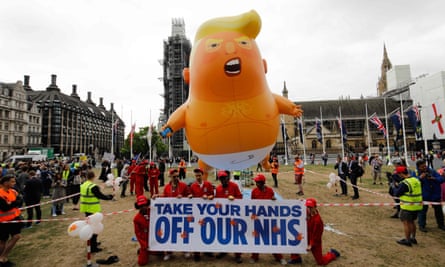 Anti-Trump demonstrators with a banner that reads ‘Take your hands off our NHS’ in Parliament Square, London, 4 June 2019.