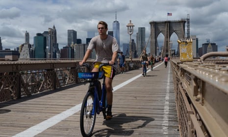 Man riding a bike over the Brooklyn Bridge.