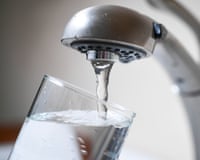 water from a faucet fills a glass