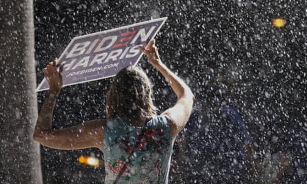 A supporter stands in the rain as Biden speaks at a drive-in rally in Tampa, Florida.