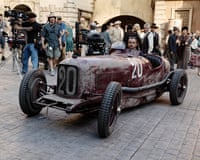 A 1930s sports car on a film set in an Italian square