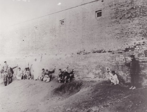 Amritsar massacre, 1919: relatives of those killed point to bullet holes in the wall, circled in white chalk