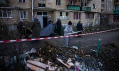 A woman throws a broken window frame in a pile near a building in Solomianskyi district that was damaged by a drone fragment on 25 November, in Kyiv, Ukraine. 