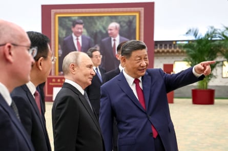 Xi Jinping points at an exhibit to Vladimir Putin