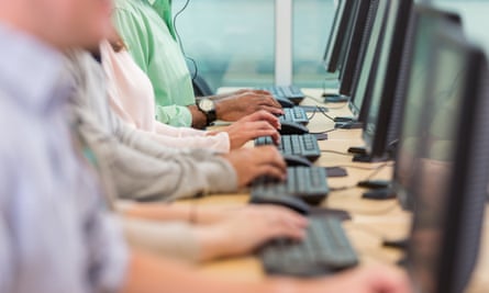 row of hands type on keyboards