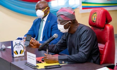 Adesola Adeduntan, left, CEO of First Bank of Nigeria, which part-funded the mobile phones, with the governor of Lagos, Babajide Sanwo-Olu.
