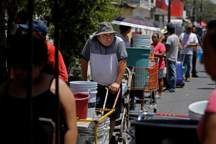 People line up with containers to collect water from a tanker truck in Nuevo Leon, Mexico.