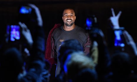Kanye West seen through raised arms in the crowd at a concert
